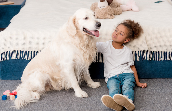 Perro sintiéndose mal junto a una niña