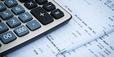 calculator sitting on top of financial documents