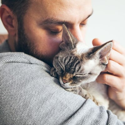 man hugging his sick cat