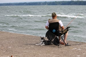 man fishing with his dog
