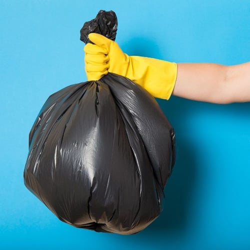 person wearing rubber gloves taking out the trash