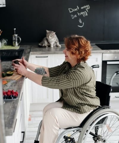woman in wheelchair preparing fruit with her cat