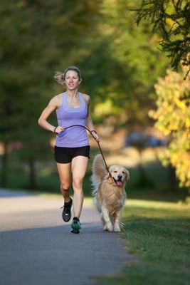 woman running with golden retriever canva 400