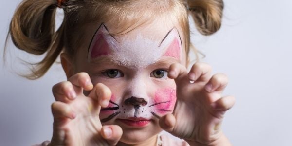 young child face painted like a cat