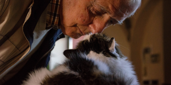 man kissing old cat
